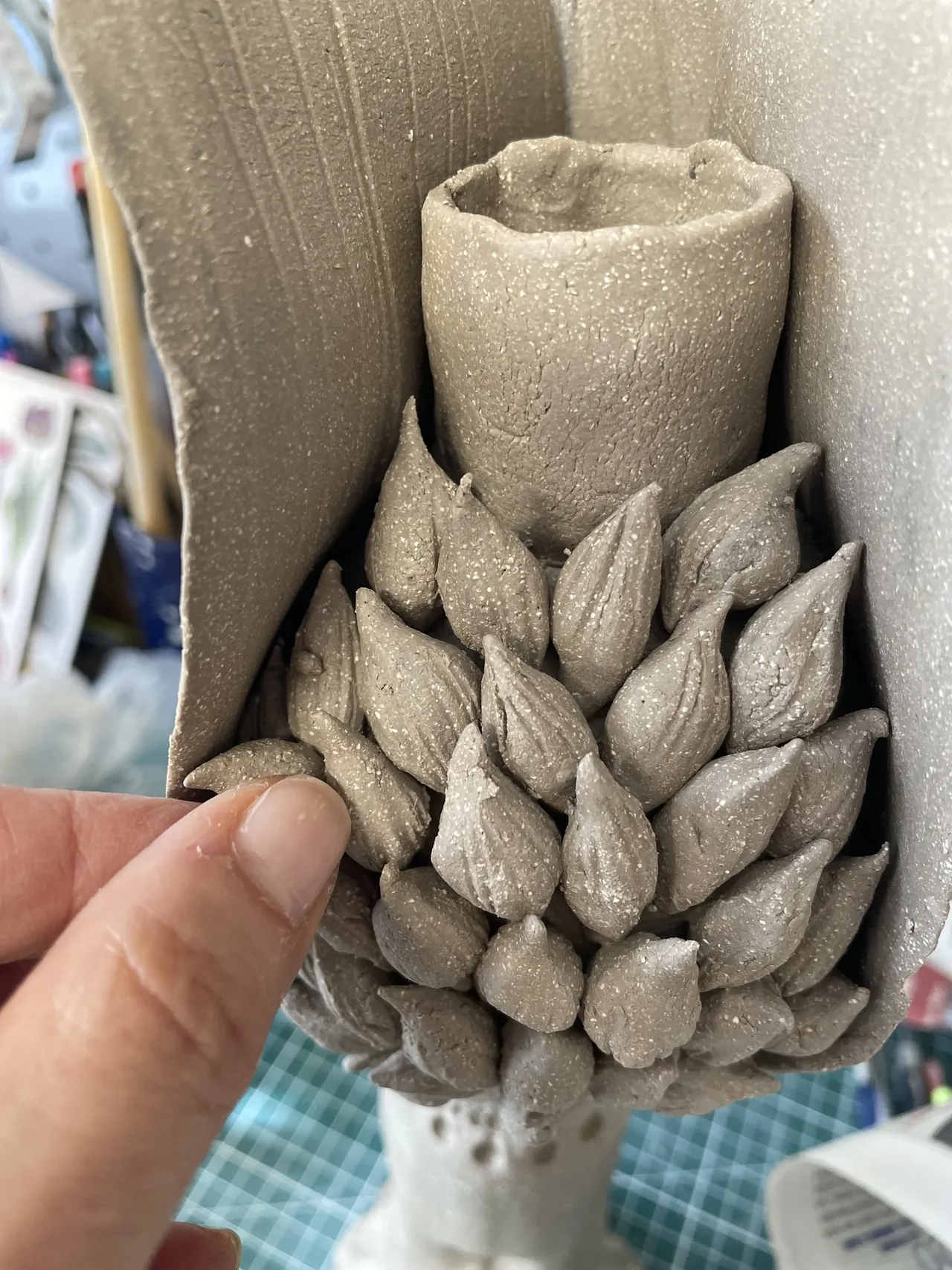 Vase artichaut en grès cru tenu en main