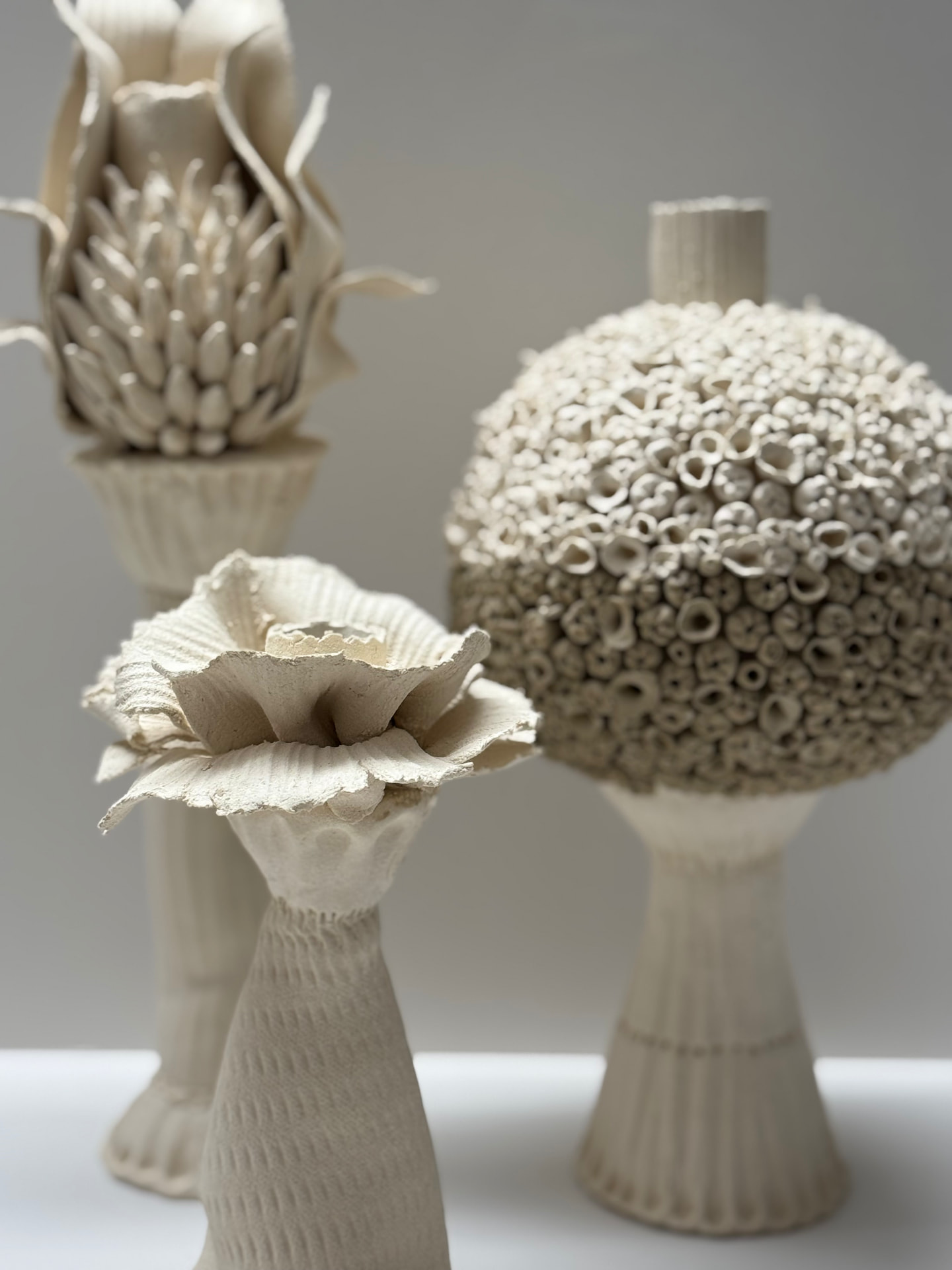 Bougeoirs artichaut, corolle et sphère corail en grès blanc, exposition Nuances