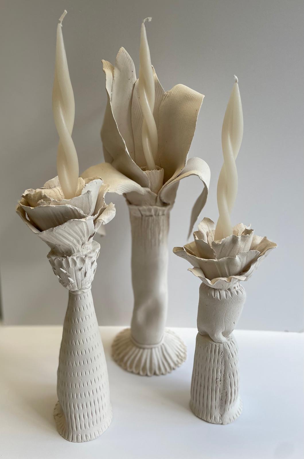 Trois bougeoirs fleurs en grès blanc