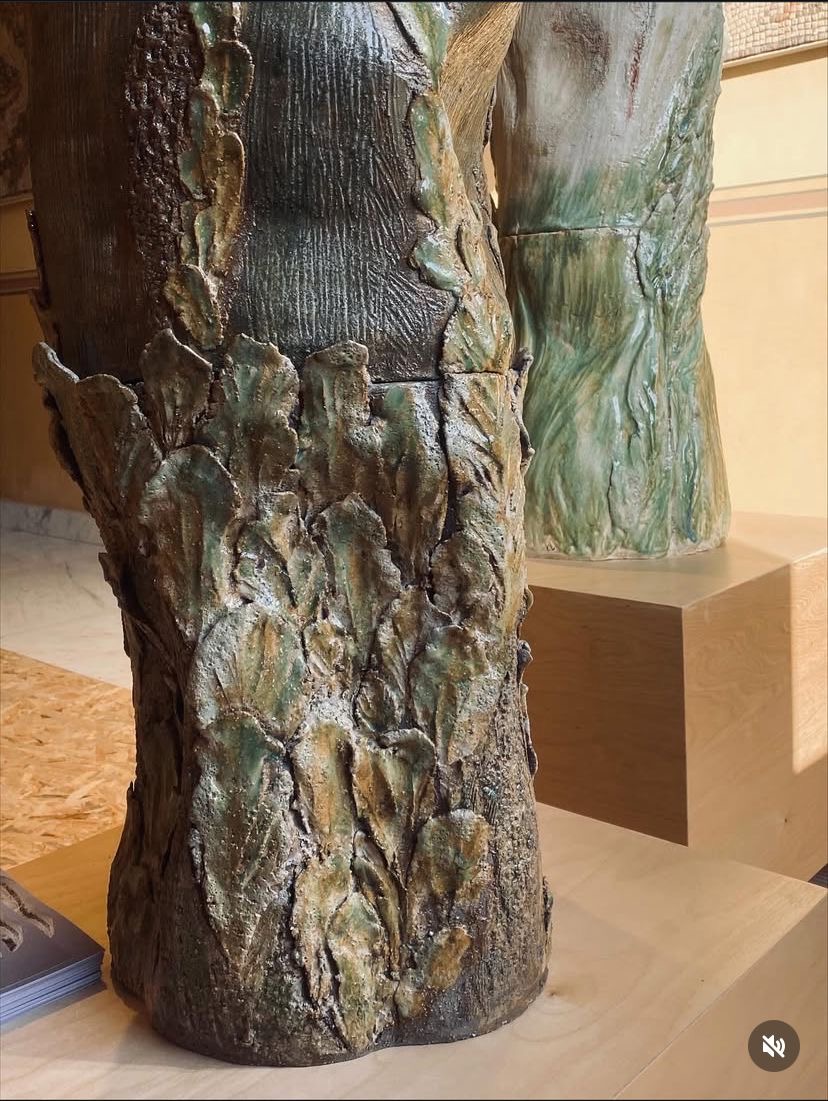 Détail de la base d'un totem en grès aux reliefs végétaux émaillés vert et ocre