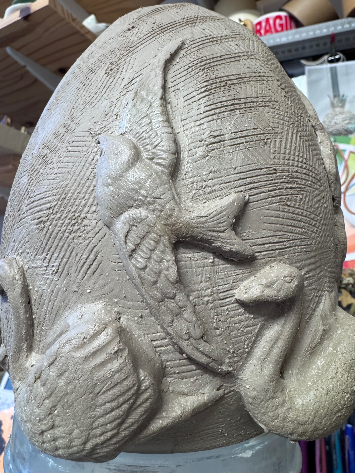 Sculpture en grès cru ornée d'oiseaux en relief, à l'atelier
