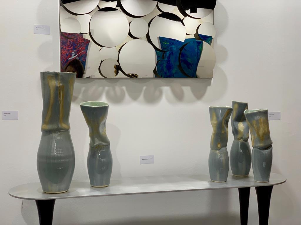 Ensemble de vases ondulés sous un miroir