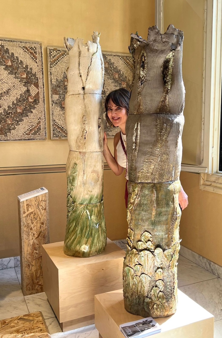 Karine Letayf debout entre deux grands totems en céramique à Villa Audi