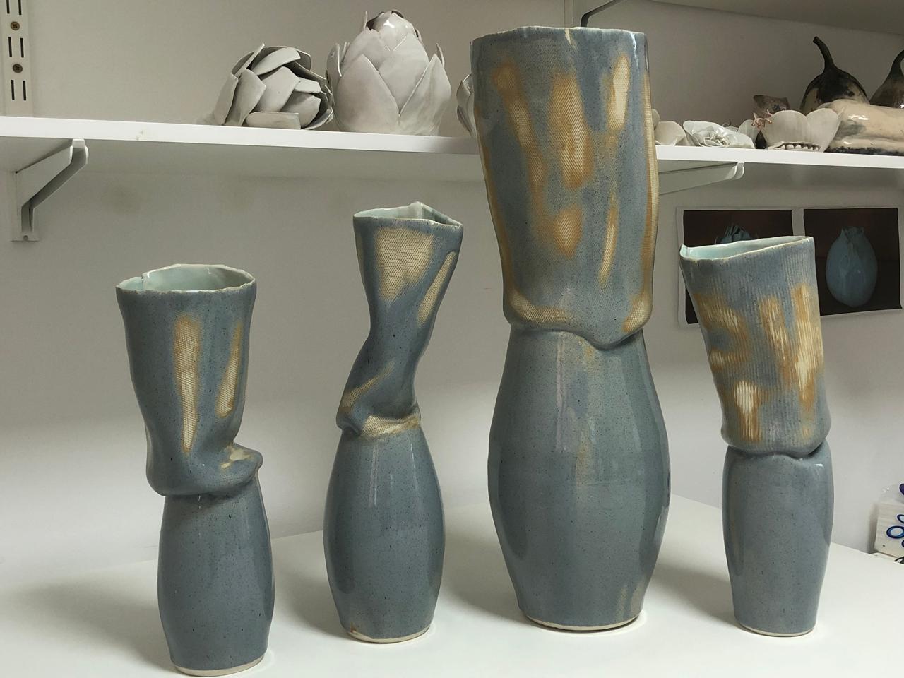 Quatre vases aux formes ondulées dans l'atelier