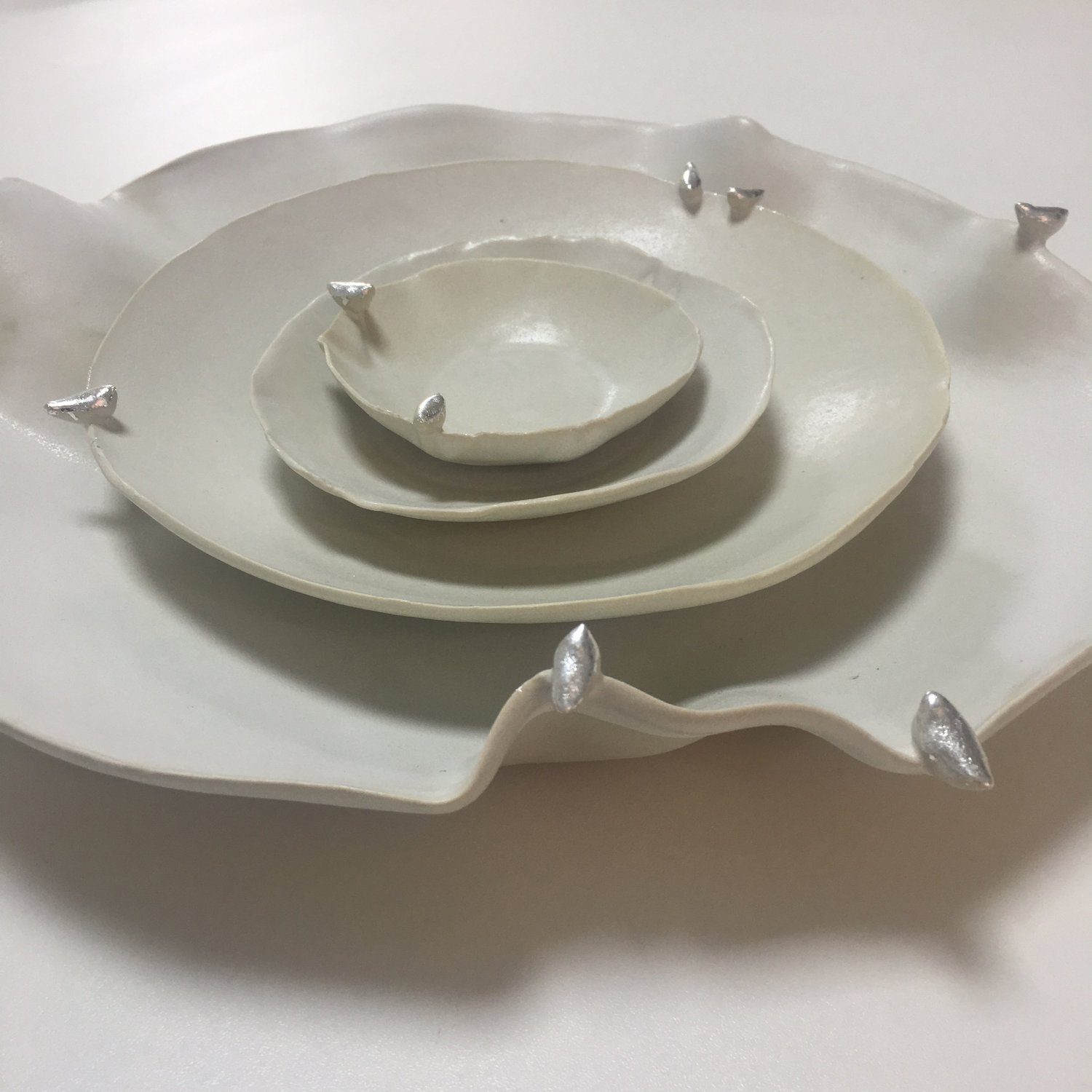 Les oiseaux, assiettes, 2017. Grès blanc, émail blanc, feuilles d'argent.